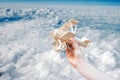 Hand launching wood airplane and blue sky in cloudy day Royalty Free Stock Photo