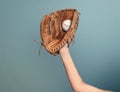 Hand in leather baseball glove caught a ball on dark gray background Royalty Free Stock Photo