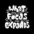 Hand Lettered What You Focus On Expands On Black Background Royalty Free Stock Photo