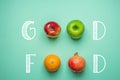 Hand Lettering Good Food on Turquoise Background with Fruits Orange Green Red Apples Pomegranate. Healthy Clean Eating Vegan