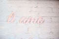 Hand lettering `ti amo` in pink color on a white brick wall