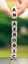 Hand lifts two dice and changes the word `anaerobic` to `aerobic.