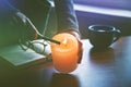 Hand lighting candle before reading book Royalty Free Stock Photo