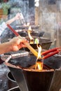 Hand lighting the incense sticks and candles at lighting lantern bowl with pouring oil to the lantern bowl in Chinese Buddhist Royalty Free Stock Photo