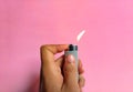 Hand lighting a lighter on pink background. decorative concept Royalty Free Stock Photo