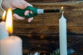 Hand lighting a white pillar in winter wreath. Royalty Free Stock Photo