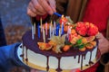 Hand lights candles on the birthday cake