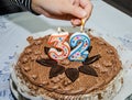 Hand lights candles on a festive cake. Number 32 on the cake. Royalty Free Stock Photo