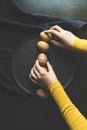 Hand lining up painted easter eggs in a row on black background, top view shot Royalty Free Stock Photo