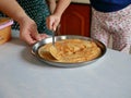 Hand of a little baby spreding pizza sauce over a pizza dough Royalty Free Stock Photo