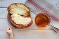 The hand of a little boy who is trying to steal my father`s sandwich with tea. Royalty Free Stock Photo