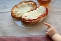 The hand of a little boy who is trying to steal my father`s sandwich with tea. Royalty Free Stock Photo