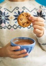 Hand of little girl dunking cookie in hot chocolate milk