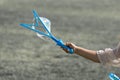 A hand of a little young girl holding a blue bubble maker and making bubbles. Royalty Free Stock Photo