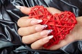 Hand with long artificial french manicured nails holding a heart Royalty Free Stock Photo