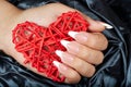 Hand with long artificial french manicured nails holding a heart Royalty Free Stock Photo