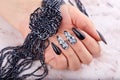 Hand with long artificial manicured nails colored with black nail polish Royalty Free Stock Photo