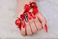 Hand with long artificial manicured nails colored with red and black nail polish Royalty Free Stock Photo