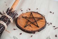 Hand made DIY besom broom and black pentagram on a white wooden table