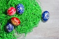 Hand made easter egg in green grass on rustick wooden background