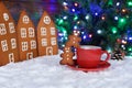 The hand-made eatable gingerbread houses, snow decoration, little men and cup of coffee, New Year Tree