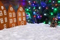 The hand-made eatable gingerbread houses, snow decoration, New Year Tree with garland Royalty Free Stock Photo