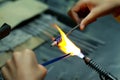 Artist of glass at work. Hand made glass beads in the fire out of red hot glowing glass for pandora bracelets,focus glass bead aro Royalty Free Stock Photo