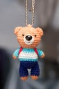 Hand made key ring teddy bear knitted doll wearing a blue and white shirt and blue planm Royalty Free Stock Photo