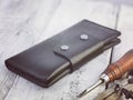 Hand made leather purse on white table and craft tools Royalty Free Stock Photo