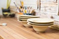 Hand made plates, bawls and tools on pottery studio table Royalty Free Stock Photo