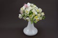 Hand made polymer clay flower bouquet in a white vase on a dark