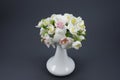 Hand made polymer clay flower bouquet in a white vase on a gray