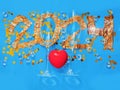 2024 hand made sign made from golden color foil, two tall elegant champagne glasses and heart shaped confetti and red heart on