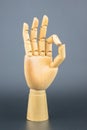 Hand made of wood Three index fingers upwards. The other 2 fingers of the hand meet in a circular OK. Royalty Free Stock Photo