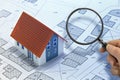 Hand with magnifying glass over cadastral map searching for building lot for building construction for sale