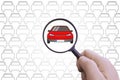 Hand with a magnifying glass searching for a car to rent or buy. Royalty Free Stock Photo