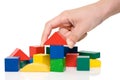 hand make a building of colored blocks.