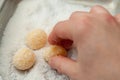 Hand making Beijinho de Coco, a traditional Brazilian candy called Coconuts Little Kiss. Top view. Horizontal shot. Close-up Royalty Free Stock Photo