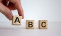 Hand making a choice between cubes with leteres A, B and C on beautiful white background. Business concept. Copy space Royalty Free Stock Photo