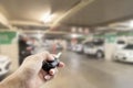 Hand male Asian ,holding car remote on Blurred image parking in Royalty Free Stock Photo