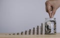 Hand of male or female putting coin in a glass jar and stack of coins to step growing growth saving money, business financial Royalty Free Stock Photo