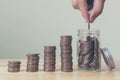 Hand of male or female putting coins in jar with money stack ste Royalty Free Stock Photo