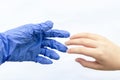 The hand of a man in blue sterile gloves greets the hand of a man without gloves on a white background. The concept of protection Royalty Free Stock Photo