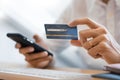 Hand of man in casual shirt paying with credit card and using smart phone for online shopping making orders via the Internet using Royalty Free Stock Photo