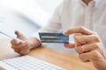 Hand of man in casual shirt paying with credit card and using smart phone for online shopping making orders via the Internet using Royalty Free Stock Photo