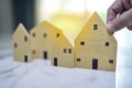 Hand of man choosing mini wood house model, Planning buy Real Estate Royalty Free Stock Photo