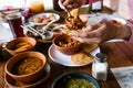 Hand of man eating Mexican tostadas or Tacos tortillas and traditional food over table, top view. Mexican cuisine