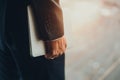 Hand of man in formal suit holdning laptop