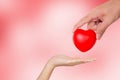 Hand of man giving red heart shape to woman, valentine day and love, relationship and romance. Royalty Free Stock Photo