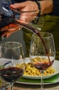 Hand of a man holding a decanter and pouring red wine in a glass Royalty Free Stock Photo